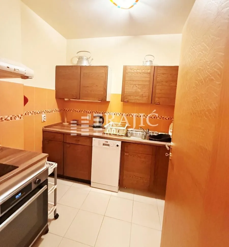 Small kitchen with wooden cabinetry and built-in appliances.