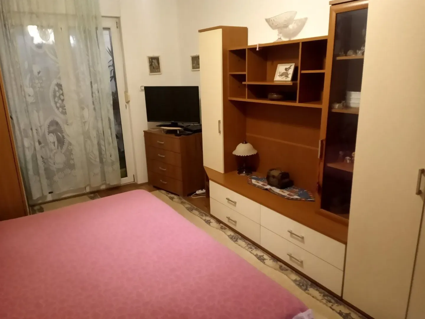 Spavaća soba sa velikim krevetom i drvenim namještajem.