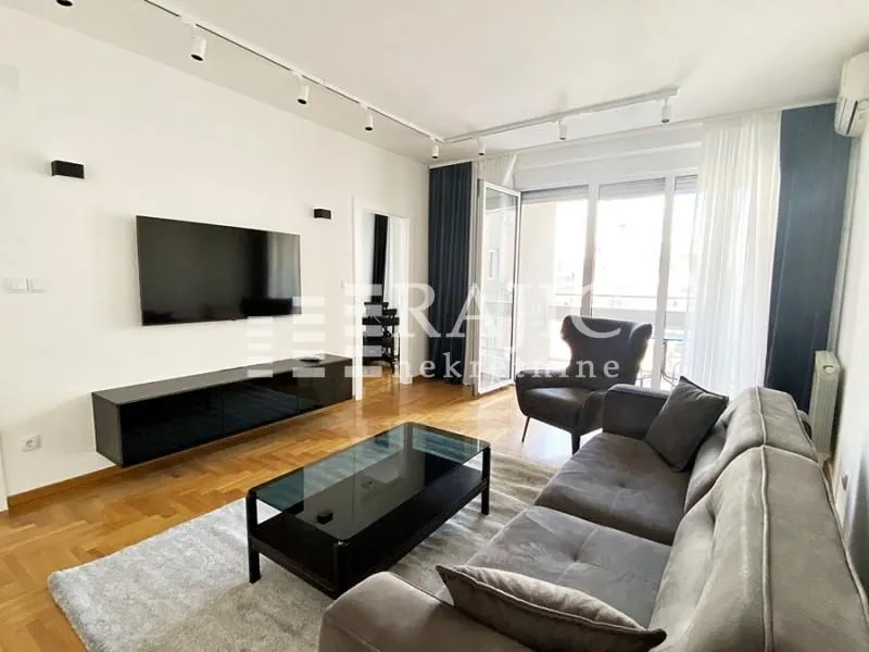 Spacious living room with sofa, TV, and access to the terrace.