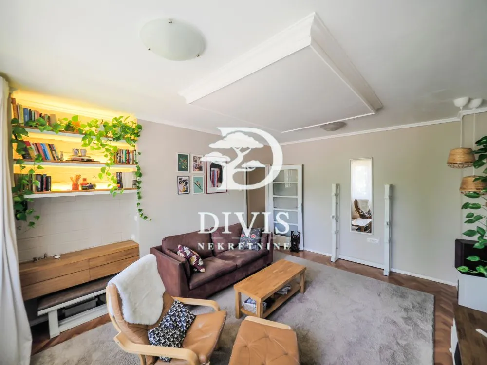 Living room with sofa, shelving unit and decorative lighting.
