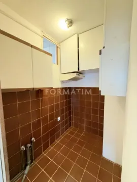 Manja kuhinja sa smeđim pločicama i belim elementima. - image 3