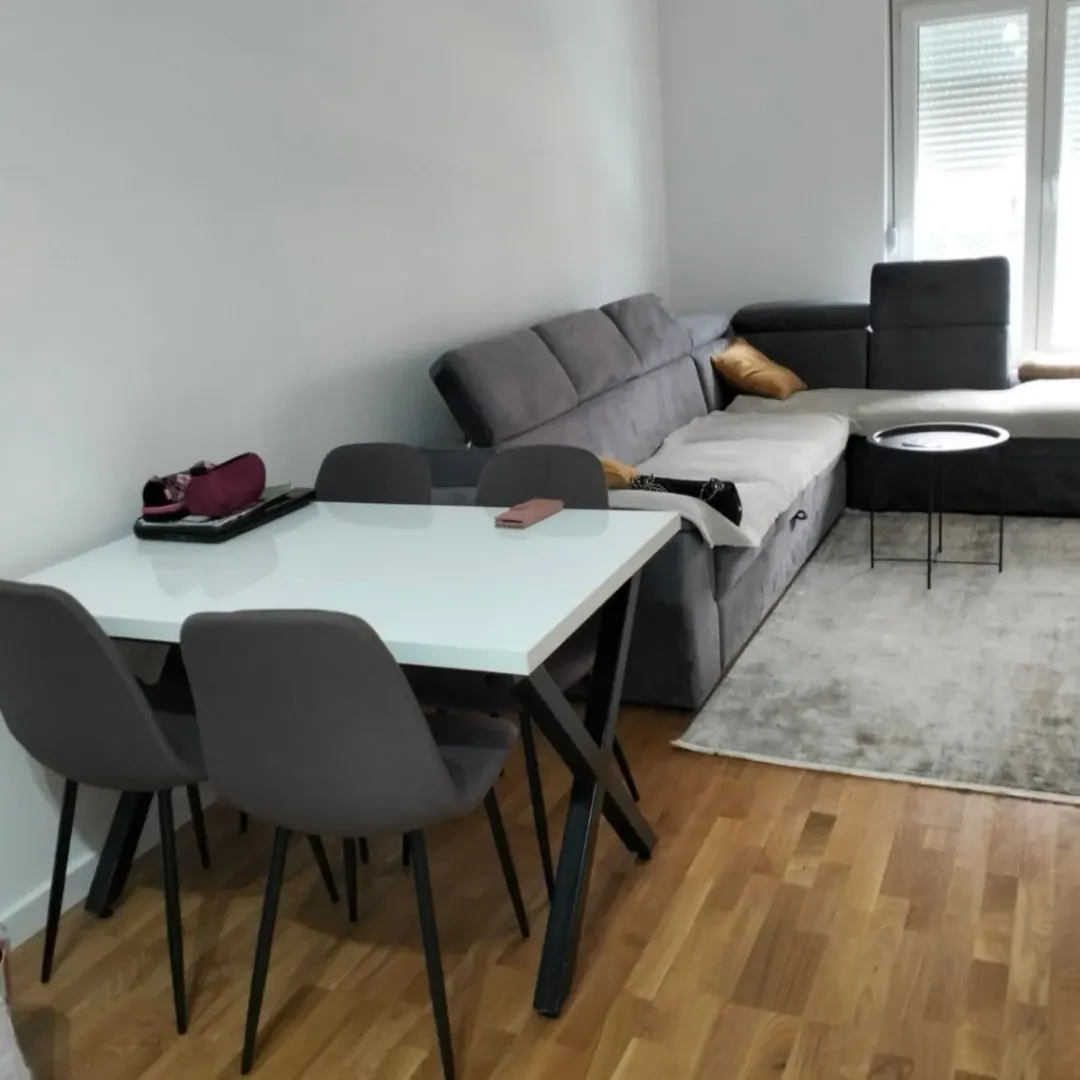 Bright living room featuring a dining table and a gray sectional sofa.