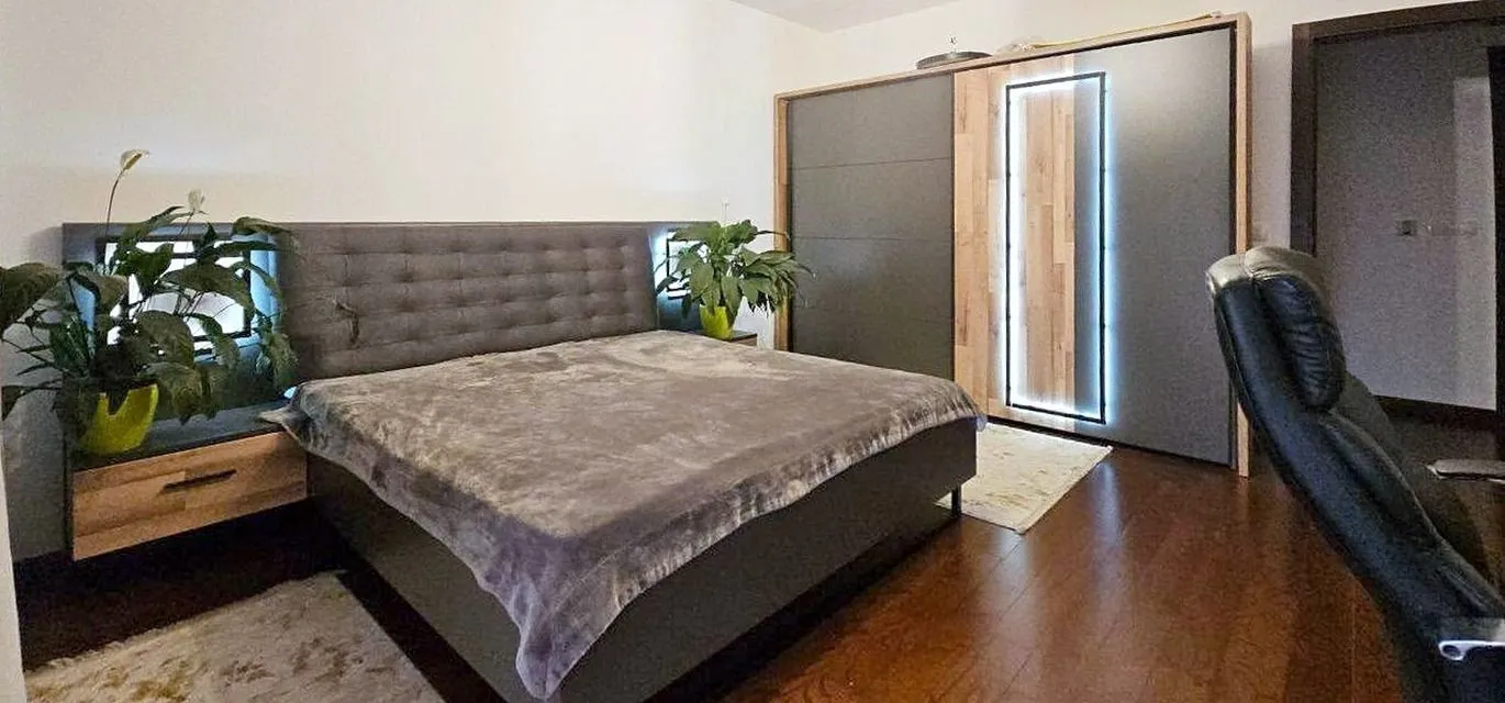 Spacious bedroom with a double bed, large wardrobe, and a desk.
