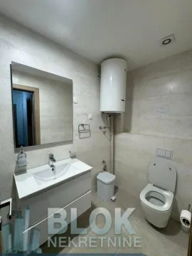 Bathroom equipped with a washbasin, toilet, and water heater. - image 2