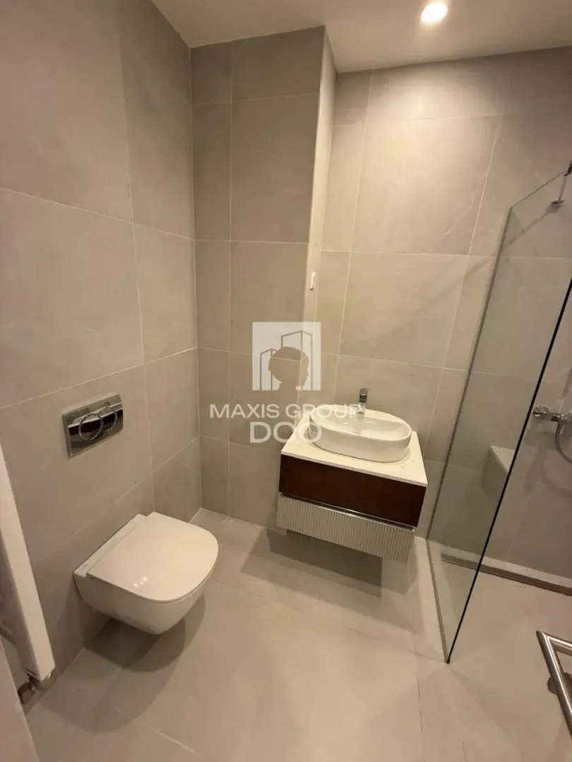 Moderno opremljeno kupatilo sa tuš kabinom, umivaonikom i WC šoljom.