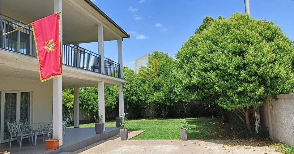 View of the courtyard and exterior of the house with a balcony.