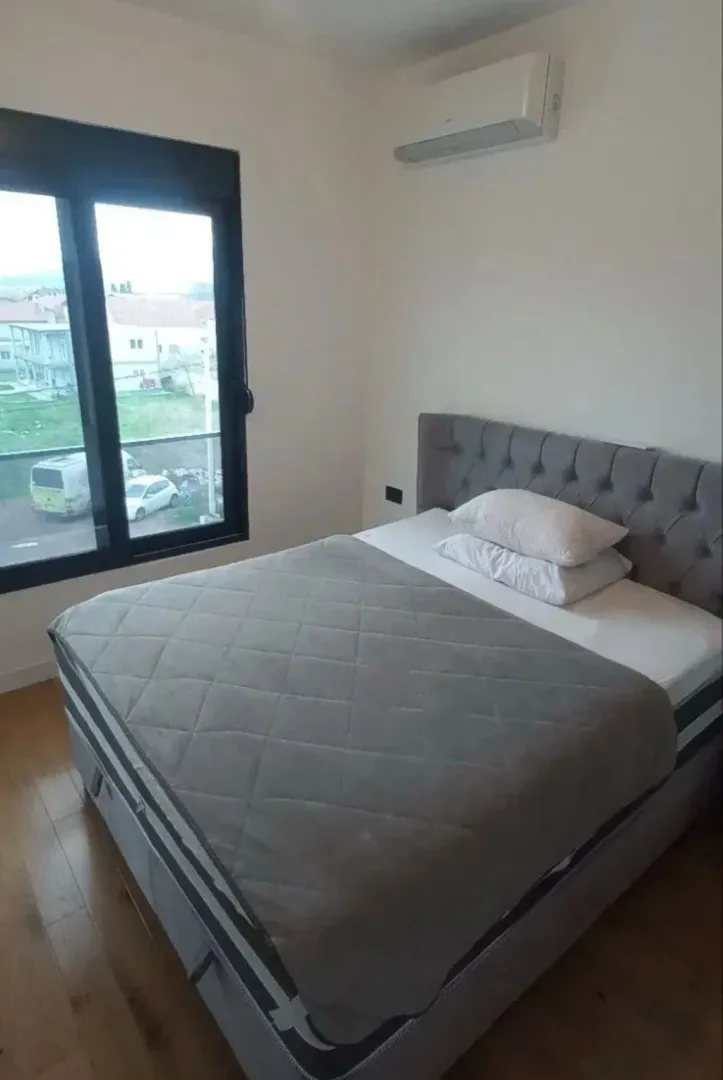 A bedroom with a double bed and an air conditioner.