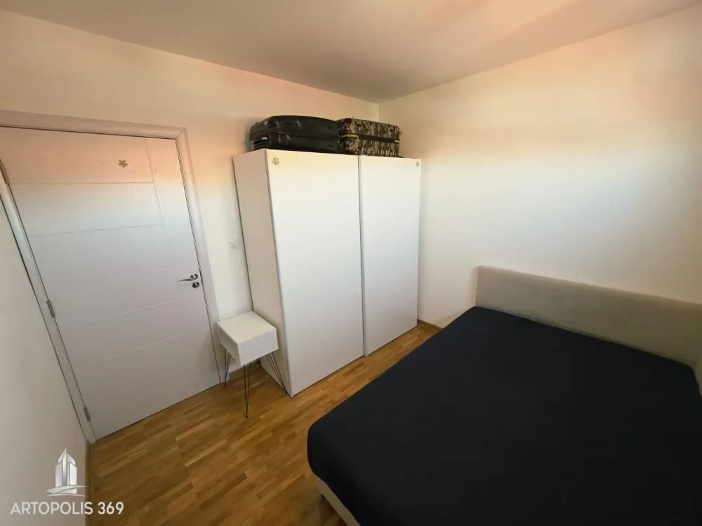 Furnished bedroom with a bed and wardrobe.