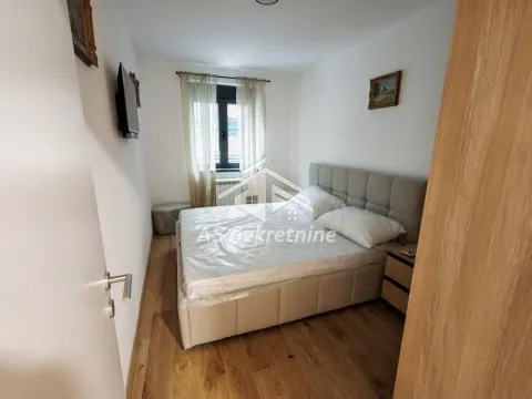 Small bedroom with a double bed, wooden floor and a window. - image 9