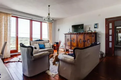 Living room with seating furniture, large windows and a TV. - image 5