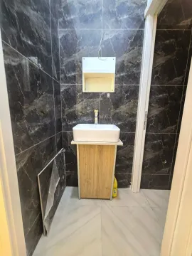 Small bathroom with a washbasin and dark marble tiles. - image 4