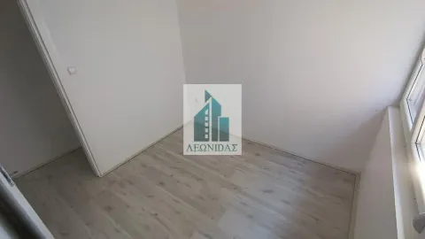 Prazna soba sa svetlim laminatom i belim zidovima. - image 8