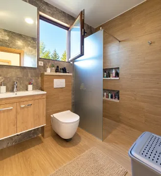 Modern bathroom featuring wood-effect tiles, wall-hung toilet, and a walk-in shower. - image 12