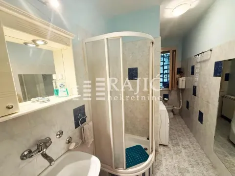 View of the bathroom with a shower cabin, washbasin, and toilet facilities. - image 3