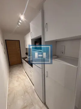 Manja bela kuhinja sa frižiderom i elementima u nizu. - image 11