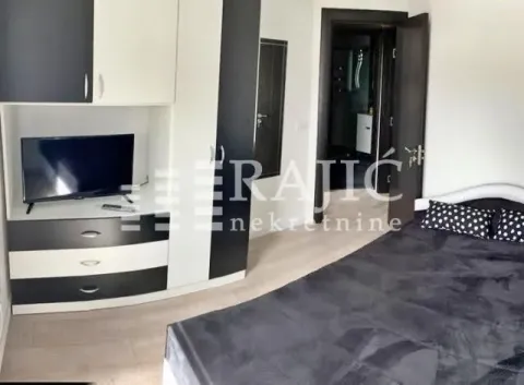 Furnished bedroom with a double bed, wardrobe, and TV. - image 6