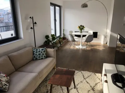 Living room with a sofa, dining table, and windows. - image 2