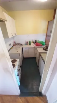 Manja kuhinja sa bijelim elementima i šporetom. - image 7