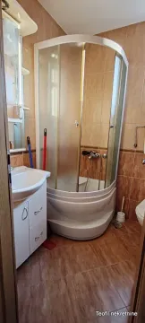 Bathroom equipped with a shower cabin, washbasin, and wall tiles. - image 5