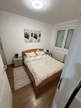 Nameštena spavaća soba sa bračnim krevetom, noćnim stočićima i prozorom. - image 7
