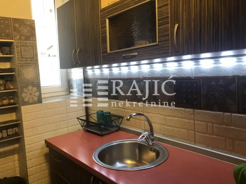 View of a section of the kitchen with a sink and wall cabinets.