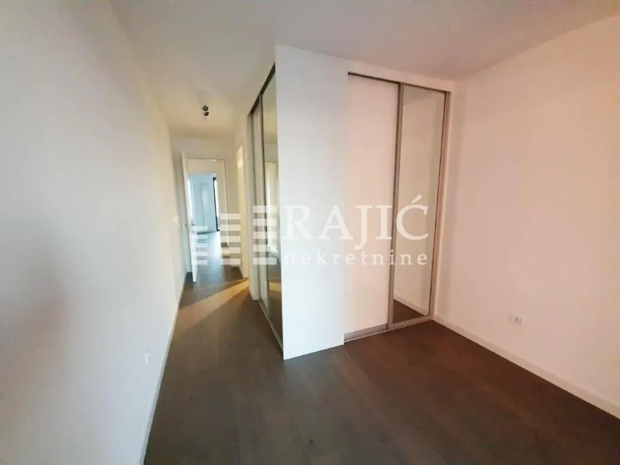 A hallway with a built-in wardrobe and doors leading to other rooms.