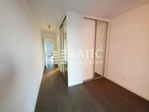 A hallway with a built-in wardrobe and doors leading to other rooms. - image 5