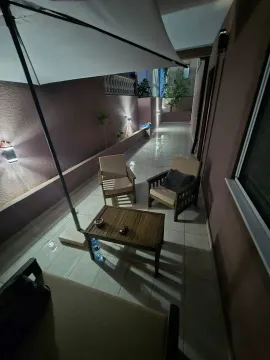 Osvijetljena terasa sa garniturom za sjedenje i suncobranom noću. - image 9