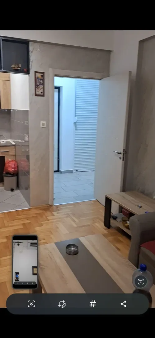 Dnevni boravak sa parketom i pogledom na hodnik i kuhinju.