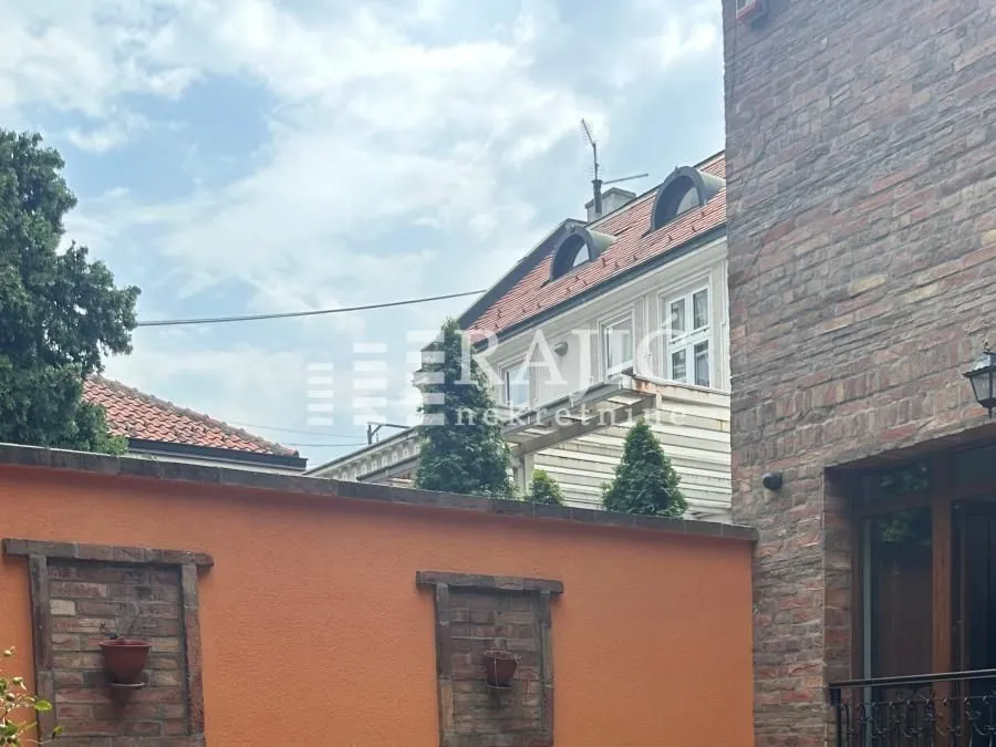 Pogled na dvorište i fasadu zgrade sa ciglom.