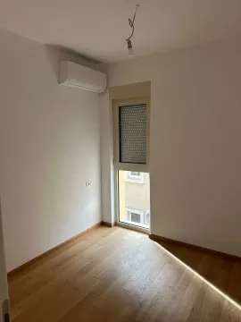 Empty room with wooden flooring, an air conditioning unit, and a window. - image 3