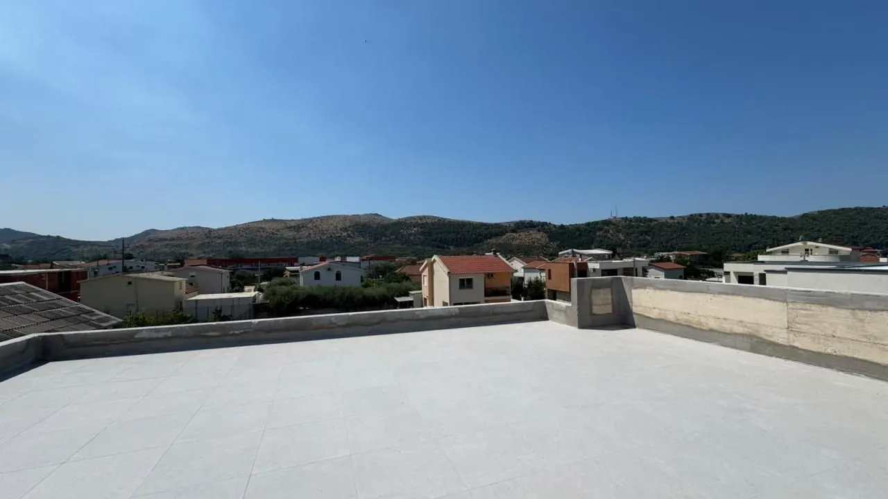 Pogled sa prostrane krovne terase na okolno naselje i brda.