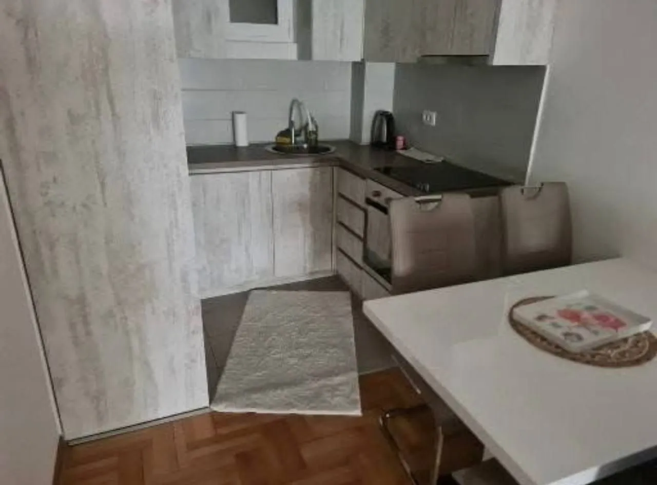 Manja kuhinja sa trpezarijskim stolom u stanu.