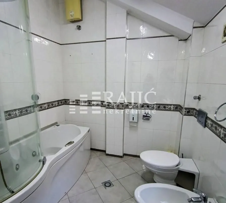 Bathroom equipped with a bathtub, shower cabin, and sanitary fixtures.