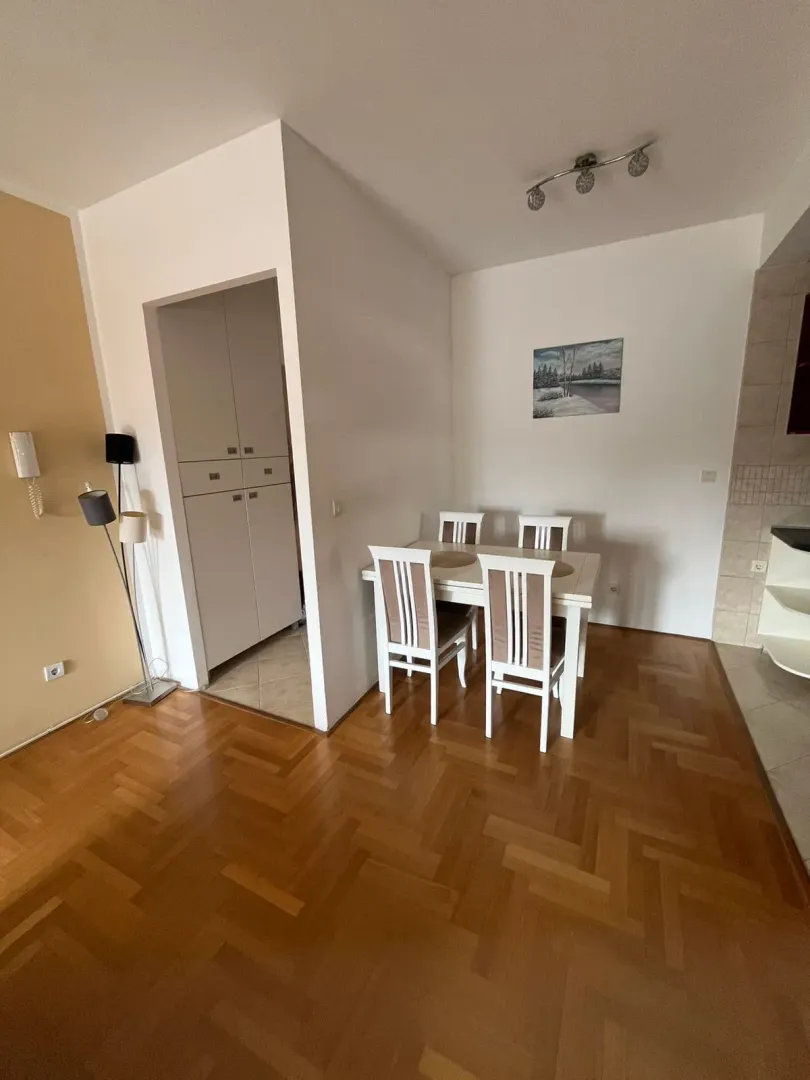 Living room with dining area and parquet flooring.