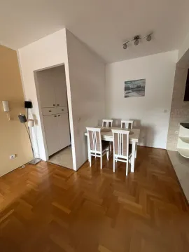 Living room with dining area and parquet flooring. - image 8