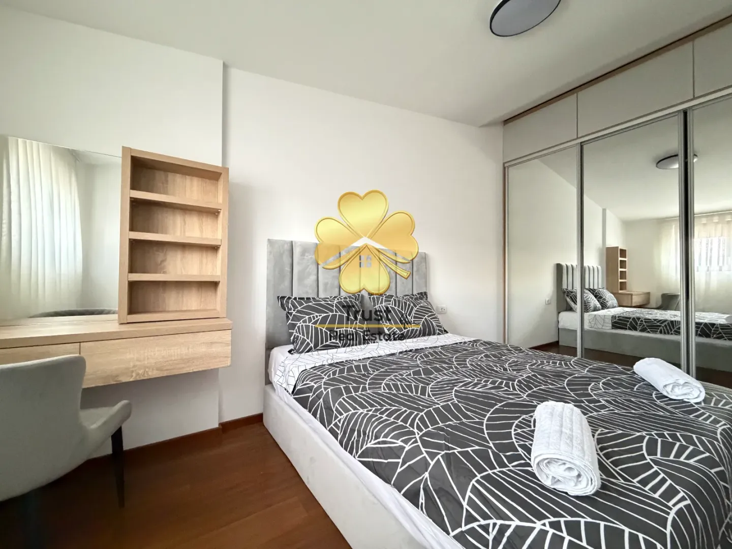 Modern bedroom with a double bed, wardrobe, and vanity table.