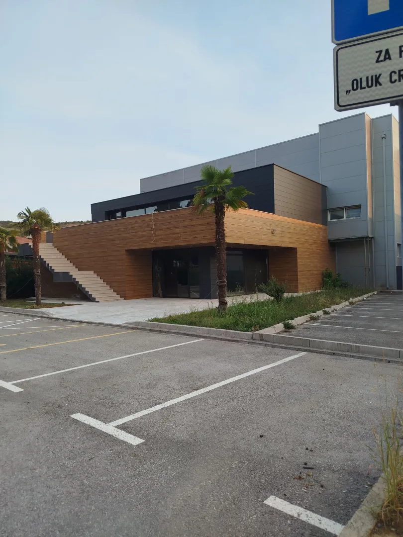 Modern commercial building with parking and a wooden facade.
