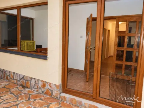 View of the entrance door and window of the house with a paved courtyard. - image 23