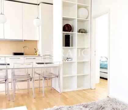 Modern white kitchen with a dining area and open shelving. - image 3