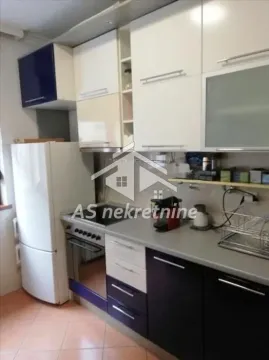 Small kitchen with white and dark cabinets and a refrigerator. - image 6