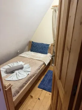 Manja spavaća soba sa krevetom za jednu osobu i drvenim podom. - image 11