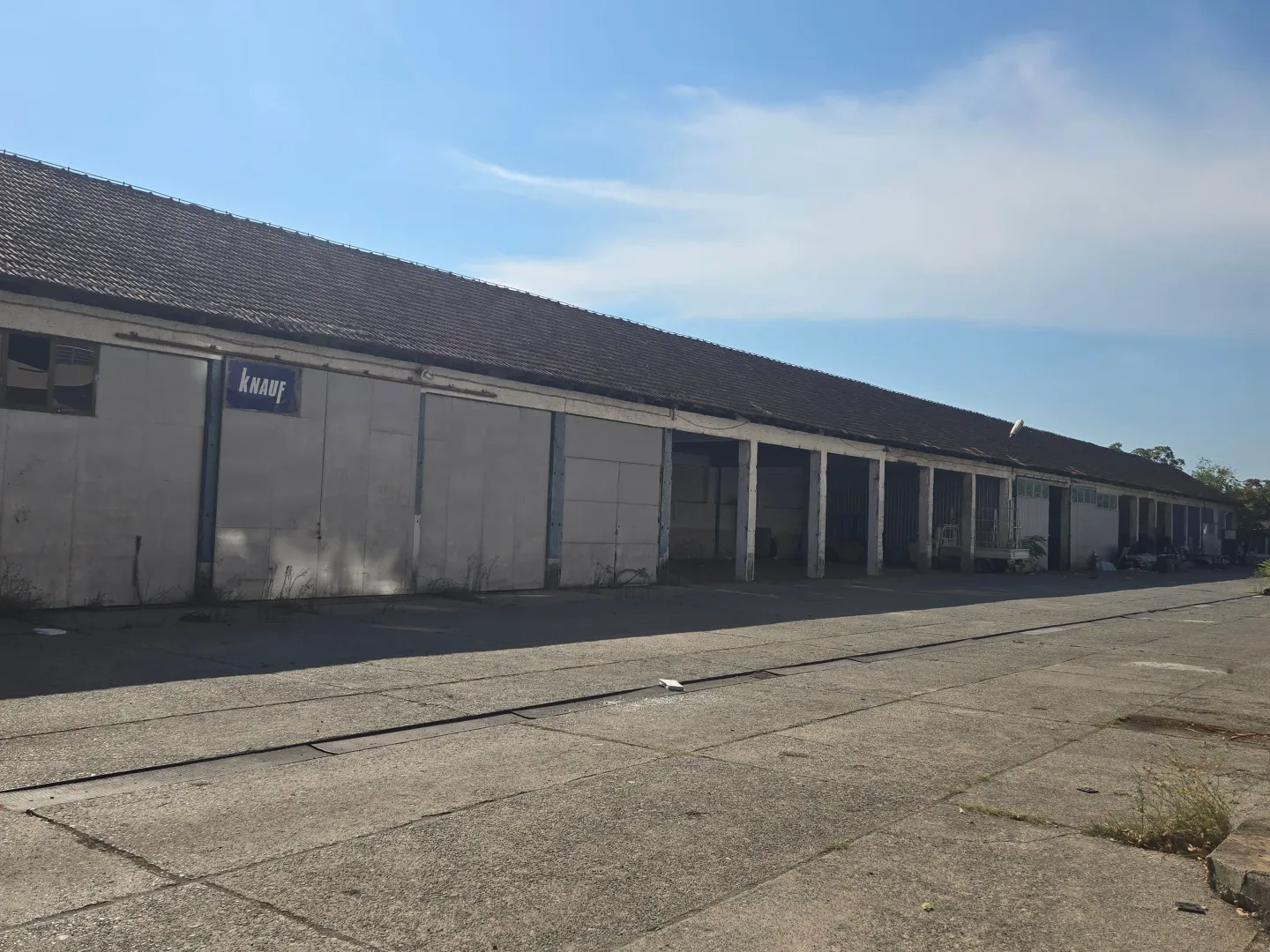 Exterior of a large industrial warehouse with an access platform.