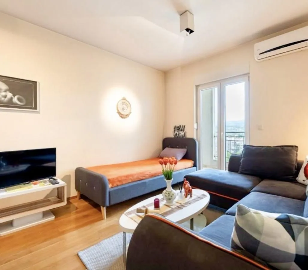 Living room with sofa, bed, and access to the terrace.