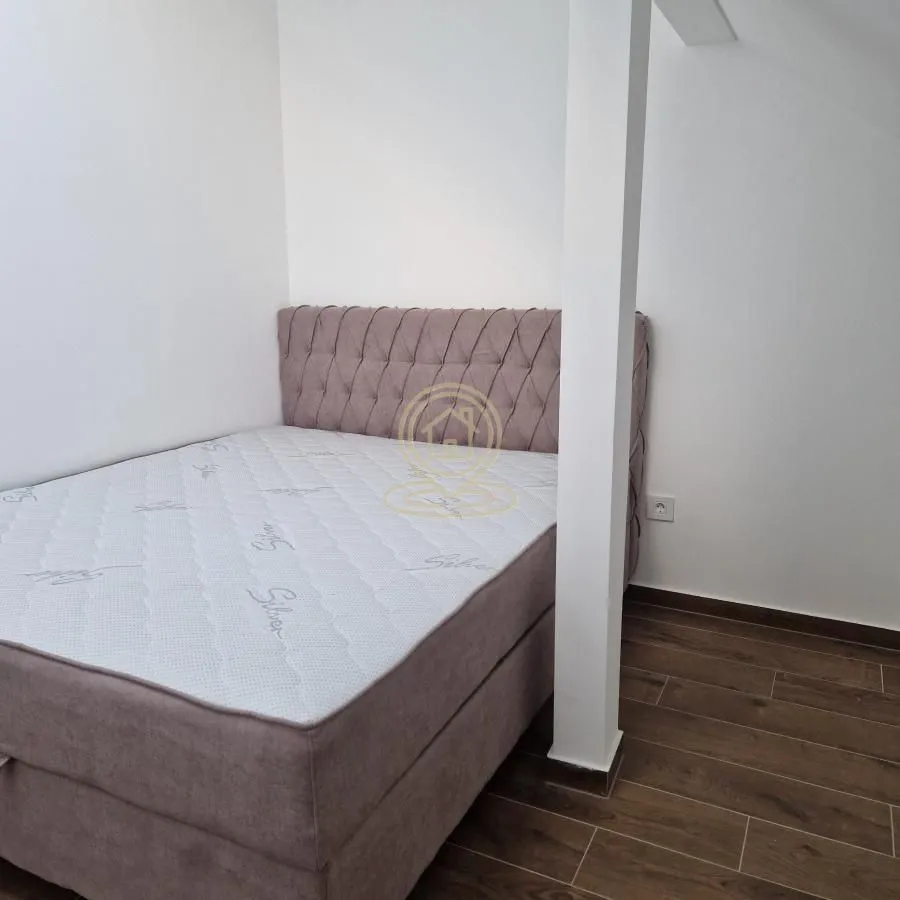 Small bedroom with a double bed and wooden flooring.
