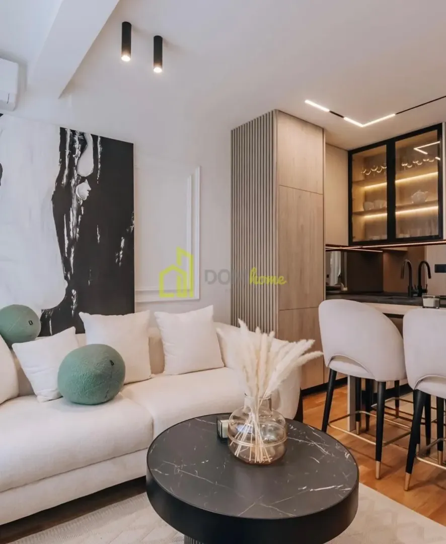 Modern living room with a sofa and view of the kitchen.