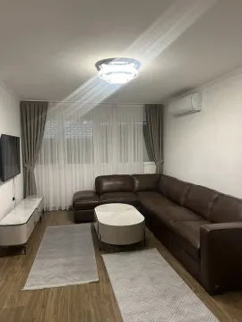 Bright living room featuring a large leather corner sofa and a TV. - image 10
