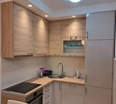 Modern corner kitchen with wooden elements and built-in appliances. - image 2