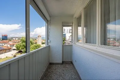 Glazed balcony with a city view.