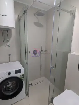 Bathroom with a shower cabin, water heater, and washing machine. - image 4